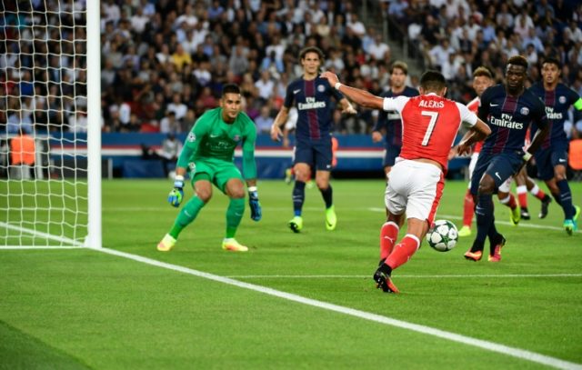 Arsenal's Chilean forward Alexis Sanchez (R) shoots during the UEFA Champions League Group