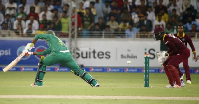 Pakistan's batsman Sarfraz Ahmed (L) hits the ball as West Indies' wicketkeeper Andre Flet