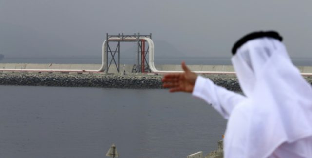 An Emirati man stands in front of a pipeline at the oil terminal of Fujairah during the in