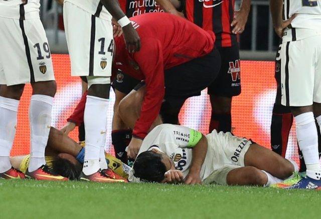 Monaco's Colombian forward Radamel Falcao (R) reacts after a crash with Nice's French goal