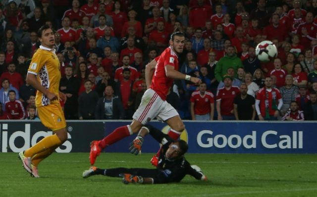 Gareth Bale (C) scores his team's third goal past Moldova's goalkeeper Ilie Cebanu on Sept