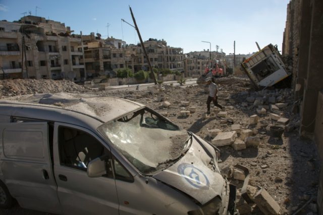 A destroyed car sits amid rubble following an air strike in the rebel-held Ansari district