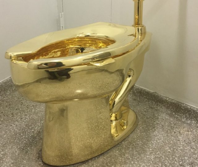 A working toilet cast in brightly gleaming gold, has been installed in a bathroom for the