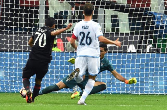AC Milan's Colombian forward Carlos Bacca (L) kicks and scores a goal during the Italian