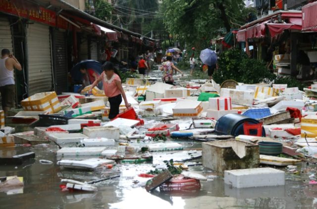 Residents gather to clean up a flooded street in Xiamen, China's eastern Fujian province a