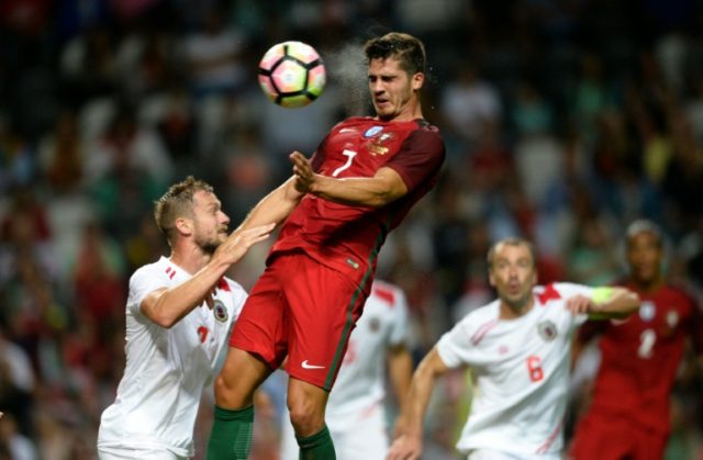Portugal's forward Andre Silva (C) heads the ball next to Gibraltar's defender Scott Wisem