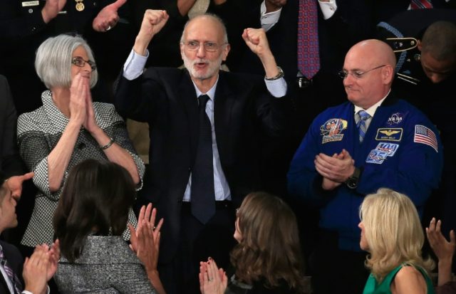 Alan Gross (C), recently freed after being held in Cuba since 2009, pumps his fist after b