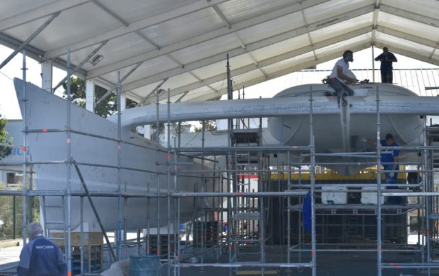 Labourers work on on the hull of an under-construction self energy producer, multihull 'En