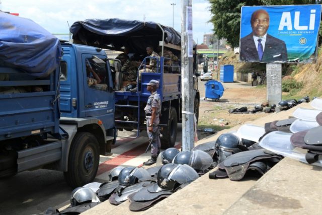 Gabonese security forces are deployed next to a campaign poster of President Ali Bongo in