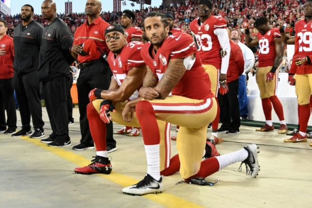 Colin Kaepernick and Eric Reid of the San Francisco 49ers kneel in protest during the national anthem prior to playing the Los Angeles Rams in their NFL game