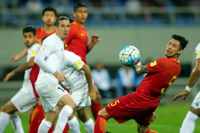 China's Zhang Linpeng (R) looks at the ball next to Iran's Andranik Teymourian (L) during