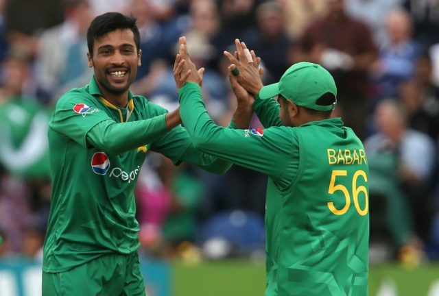 Pakistan's Mohammad Amir (L) celebrates a wicket with Babar Azam during the fifth one-day