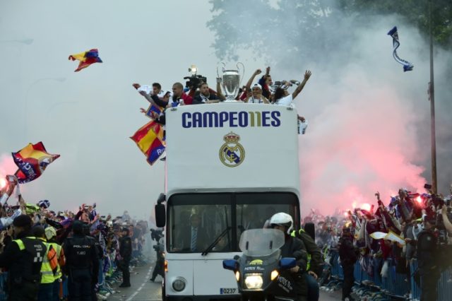 Fans surround the bus as Real Madrid players parade with the 2016 UEFA Champions League tr