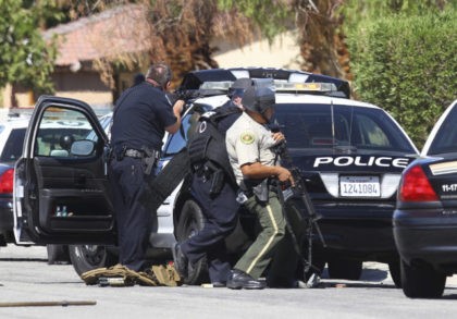 Officers watch to a home on Cypress Road after a gunshots where fired in Palm Springs, Cal