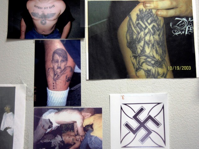 Photographs showing neo-Nazi and gang tattoos hang in the gang unit office at the police station in Buena Park, Calif., Feb. 24, 2007. The white supremacist gang Public Enemy No. 1 began two decades ago as a group of teenage punk rock fans from upper-middle class bedroom communities in Orange County. Now, it's spreading to other Western states and gaining power as federal authorities weaken the Aryan Brotherhood and other established white supremacist gangs with racketeering charges and other crackdowns. (AP Photo/Ann Johansson)