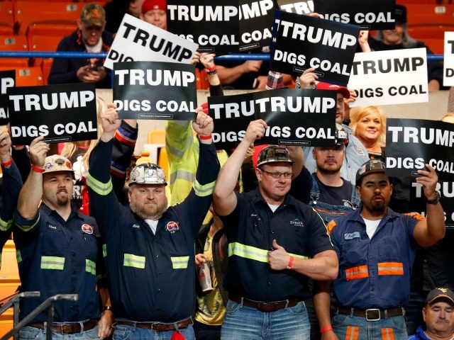 A group of coal miners wave signs for Republican presidential candidate Donald Trump as th