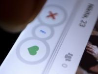 FILE - In this July 5, 2015, file photo, a man uses the dating app Tinder in New Delhi. Streaming music service Spotify announced on Sept. 20, 2016, that it is teaming with Tinder to allow users of the dating app share musical preferences on their Tinder profiles. (AP Photo/Tsering …