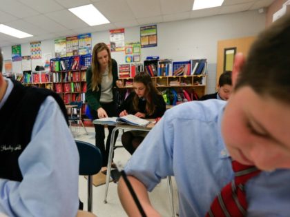 In this Tuesday, Nov. 17, 2015 photo, teacher Nicoleen Winklarek works with students in a seventh grade accelerated math class at Holy Spirit School in East Greenbush, N.Y. The Diocese of Albany, New York, announced recently that it will reduce the frequency of the Common Core-aligned tests while sticking with …