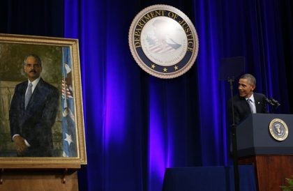 US President Barack Obama looks at the unveiled portrait of outgoing Attorney General Eric