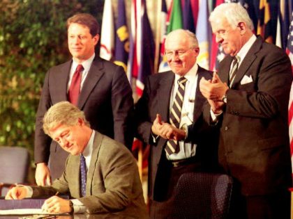President Bill Clinton signs the North American Free Trade Agreement (NAFTA) 08 December 1993 as, from left, Vice President Al Gore, House Minority Leader Bob Michel, R-Ill., and Speaker of the House Tom Foley, D-Wash., watch.