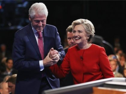 Democratic presidential nominee Hillary Clinton (R) shakes hands with husband and former U