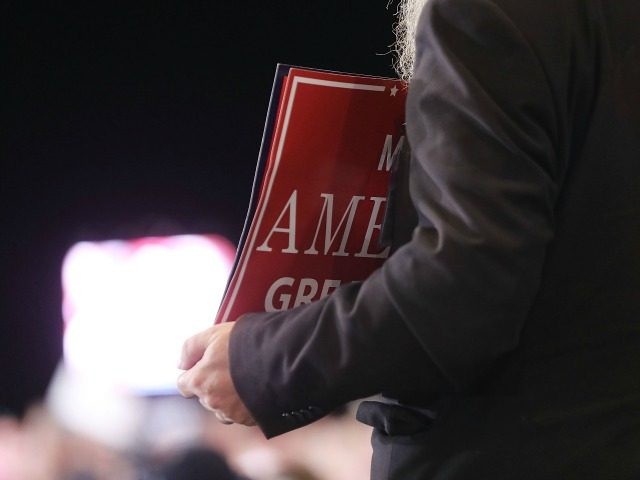 A person holds a 'Make America Great Again' sign at a Donald Trump rally as he s