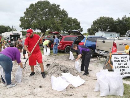 Locals scramble to fill sandbags with the last of a supply at the Road and Bridge Departme