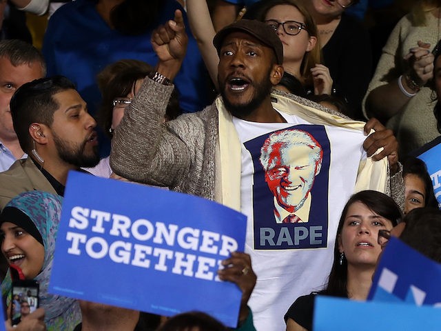 DETROIT, MI - OCTOBER 10: A protester wears a shirt with an image of former U.S. president Bill Clinton and the word 'rape' as democratic presidential nominee former Secretary of State Hillary Clinton speaks during a campaign rally at Wayne State University on October 10, 2016 in Detroit, Michigan. A …