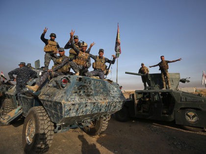 Iraqi forces flash the sign for victory as they deploy in the area of al-Shourah, some 45 kms south of Mosul, as they advance towards the city to retake it from the Islamic State (IS) group jihadists, on October 17, 2016. Iraqi Prime Minister Haider al-Abadi announced earlier in the …