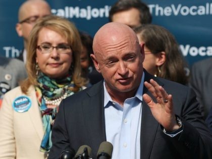 Gun violence victim and former U.S. Congresswoman Gabby Giffords watches her husband, NASA astronaut Mark Kelly, speak as they visits City Hall on her 2016 Vocal Majority Tour on October 17, 2016 in New York City.
