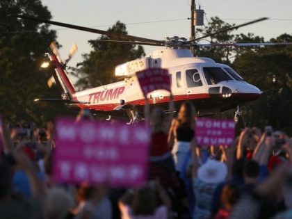 People watch as the helicopter carrying Republican presidential candidate Donald Trump leaves after a campaign rally at the Collier County Fairgrounds on October 23, 2016 in Naples, Florida. Early voting in Florida in the presidential election begins October 24. (Photo by )