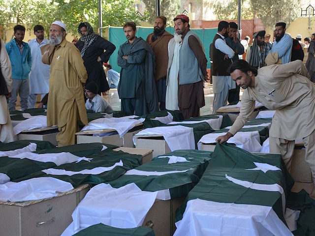 Pakistani mourners gather around the coffins of some of those killed in an attack on the P