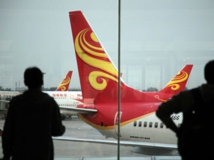 Passengers look on June 12, 2014 at planes belonging to China's Hainan Airlines at the gat