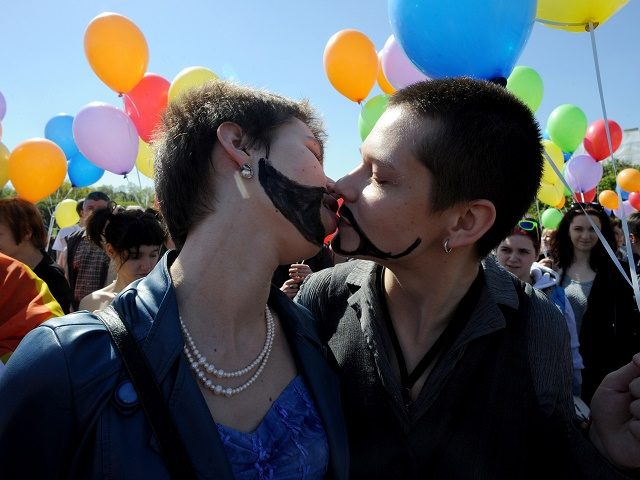 Gay rights activists kiss as they take part in a flash mob devoted to the World Day Agains