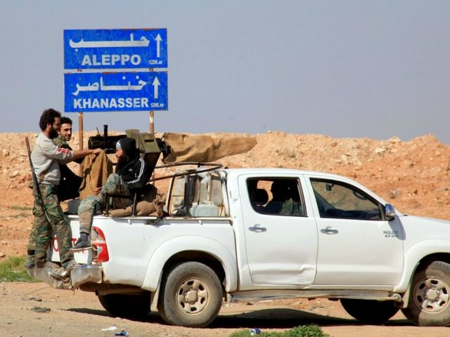 Syrian pro-government forces advance on a road through the town of Khanasser, which is the