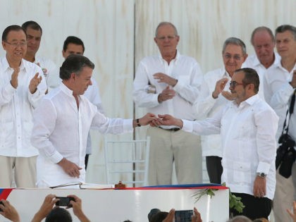 Colombia's President Juan Manuel Santos, front left, gives a peace pin to the top commande