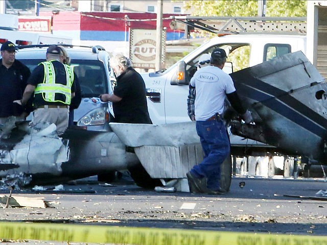 Wreckage is removed from the scene of a twin-engine plane that struck a utility pole and b