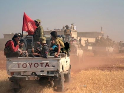 Syrian rebel fighters ride in the back of a pick-up truck flying an Islamist flag in the northern Syrian village of Rael after they captured it from the Islamic State (IS) group in the Marj Dabiq area north of the embattled city of Aleppo on October 9, 2016. / AFP …