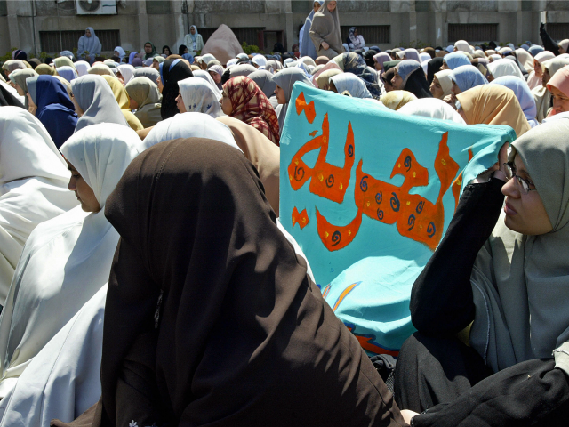 A banner reading in Arabic, 'Freedom' is seen among scores of veiled female stud