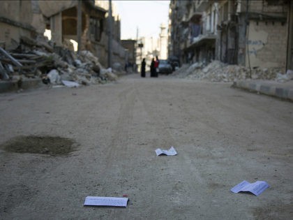 Flyers reportedly distributed by the government encouraging people to leave a rebel-held area in the northern embattled city of Aleppo are seen lying in the street on October 20, 2016. A 'humanitarian pause' in the Syrian army's Russian-backed assault on Aleppo took effect but despite a drop in violence there …