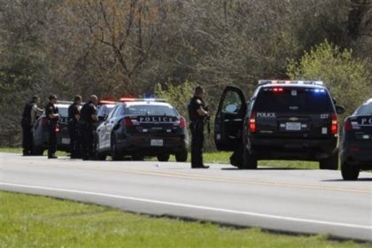 Heavily armed law enforcement officials work the scene where an officer was wounded in wes