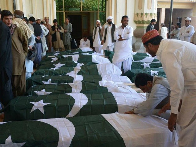 Pakistani mourners gather around the coffins of some of those killed in an attack on the P