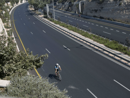 A man rides his bicycle on a car-free highway in Jerusalem during the solemn Jewish fast of Yom Kippur on October 4, 2014. Yom Kippur, which means the Day of Atonement, is marked with a 25-hour fast beginning before sunset the previous day. Israel was in security lockdown for the …