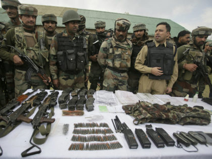Indian Army soldiers display arms and ammunition recovered with the bodies of suspected mi