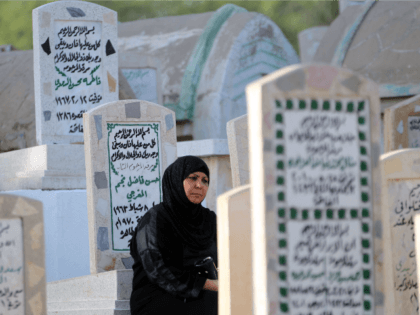 An Iraqi woman prays at the grave of a loved one at a cemetery in the capital Baghdad on J