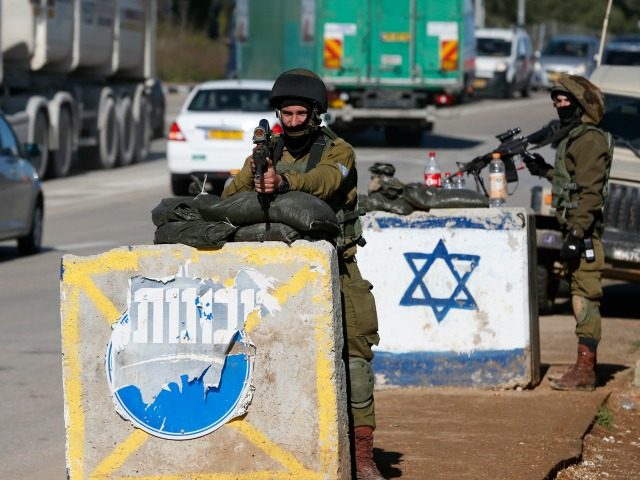 Israeli soldiers keep watch at the Gush Etzion junction, south of Jerusalem in the Israeli-occupied West Bank, following a car ramming attack on March 4, 2016. A Palestinian woman injured an Israeli soldier in the car-ramming attack before troops at the scene shot her dead, the army said. / AFP …