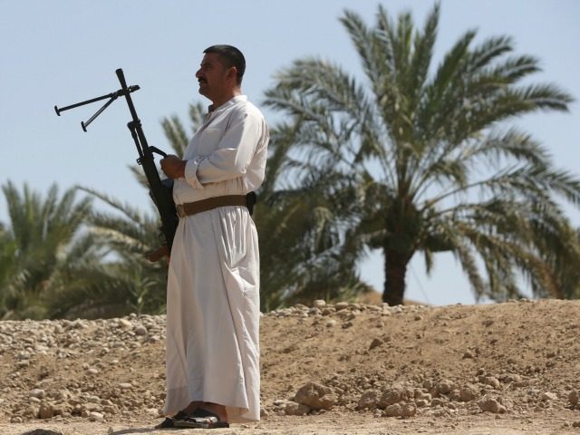 An Iraqi man carries his weapon in the Iraqi town of Jdaideh in the Diyala province on Jun