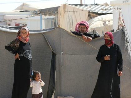 Syrian refugees stand at the Zaatari refugee camp, located close to the northern Jordanian