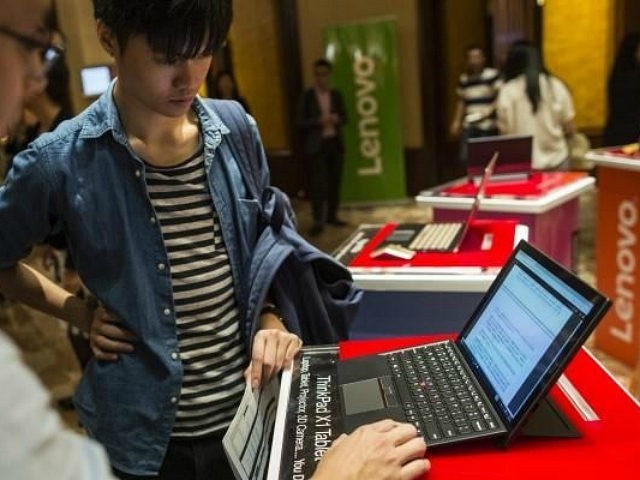 Attendees look at a Lenovo Group Ltd. ThinkPad X1 laptop computer ahead of a news conferen