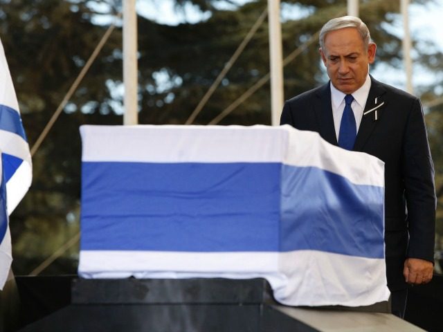 Israeli Prime Minister Benjamin Netanyahu stands before the coffin of former Israeli presi
